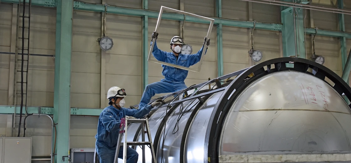 タンクの上でフレームを設置する作業員