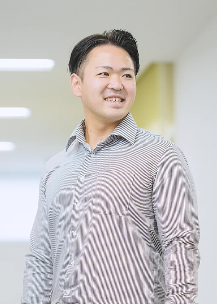 オフィスでシャツとネクタイを着た男性が立っている様子