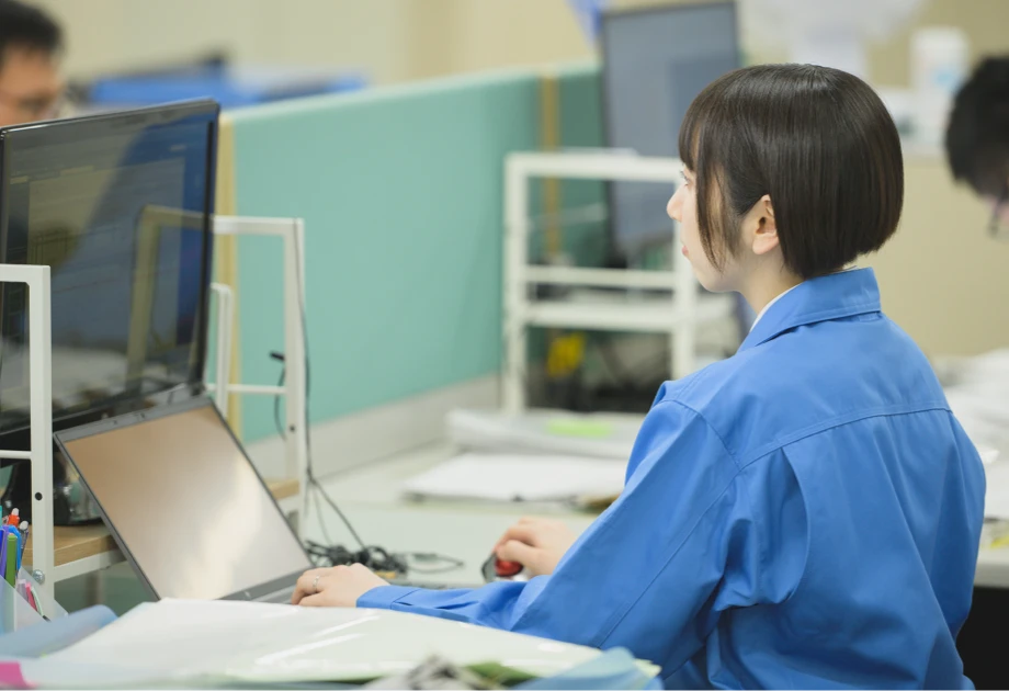 集中してマルチモニターでPC作業を行う女性社員