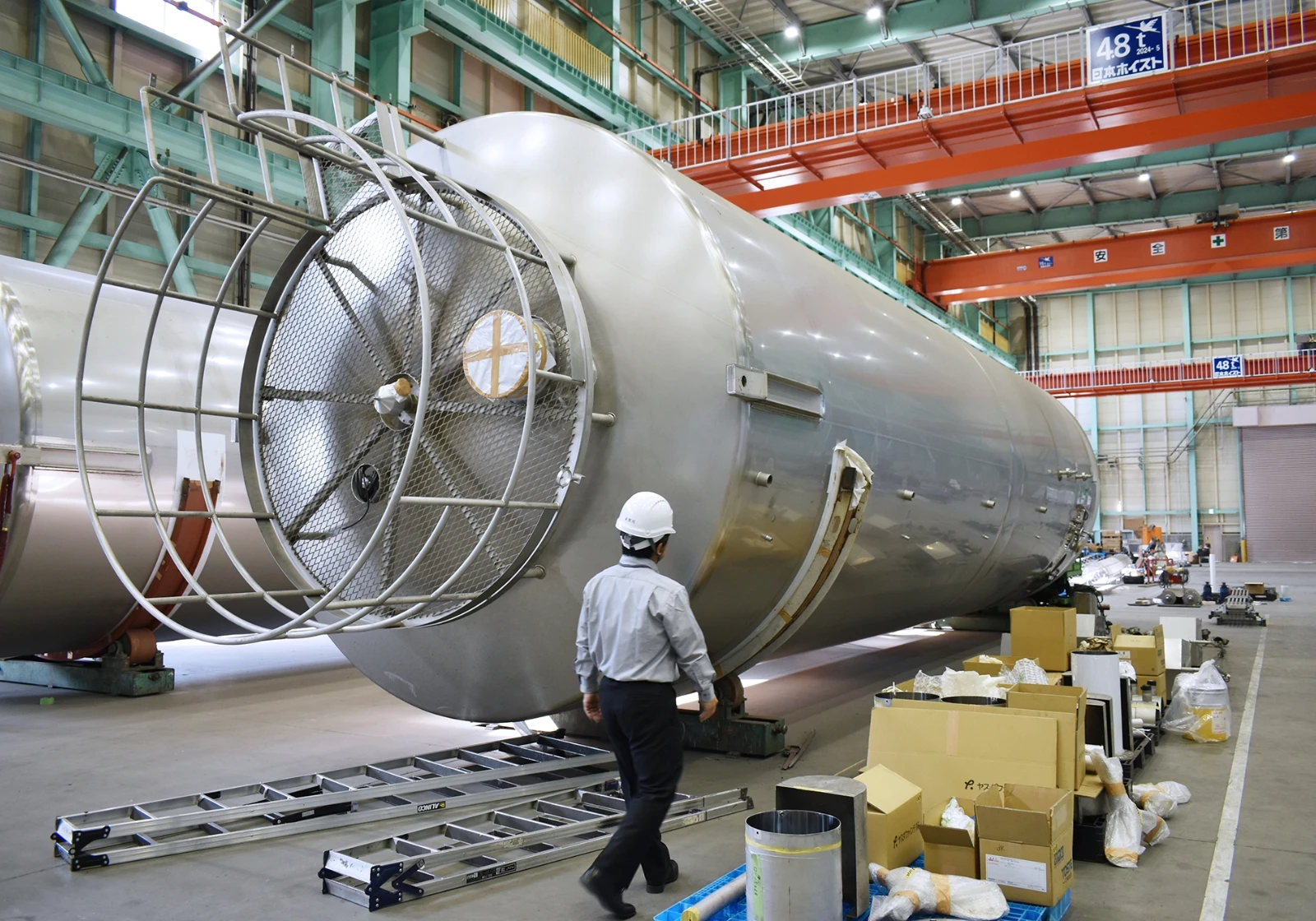 工場内で大型タンクを点検する作業員の様子