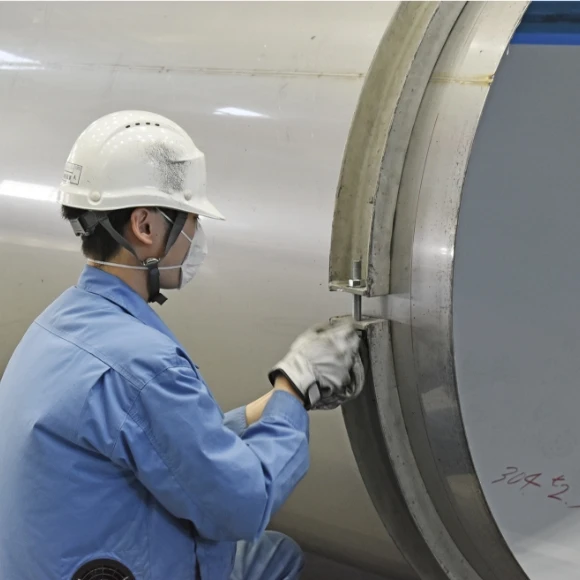 工場作業員が産業機械のメンテナンスを行っている様子