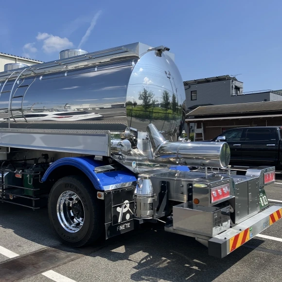 ステンレス製タンクトレーラーが駐車場に停まっている写真