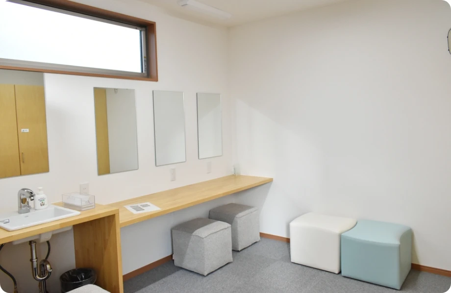 シンプルで清潔なメイクアップルーム、鏡と収納スツール付き