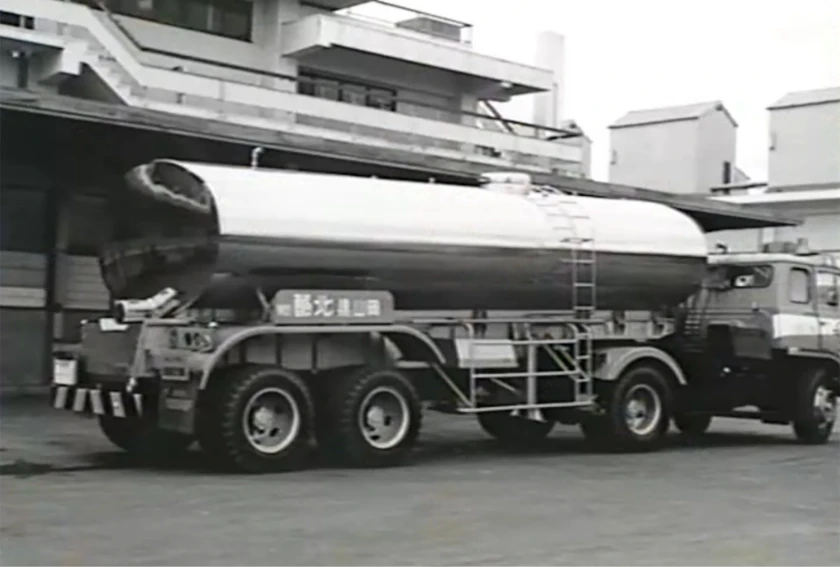 タンクローリー車の黒白写真、工場の前に停車している。