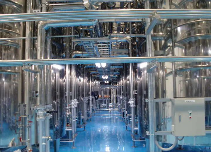 工場のステンレス製パイプとタンクの内部設備。