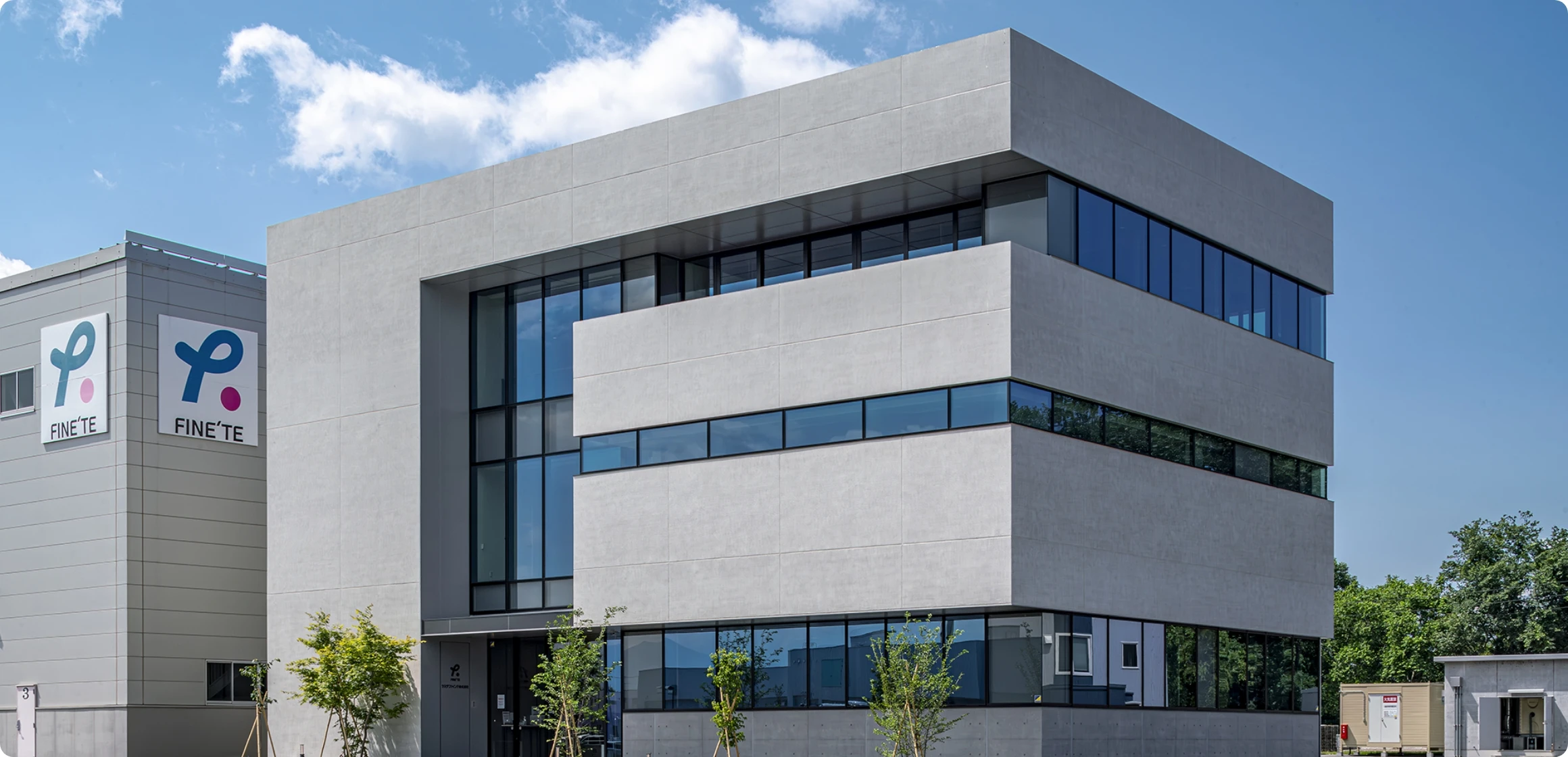 白いコンクリートの現代的なオフィスビルと青空。