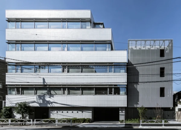 都市の近代的な白い多階建てオフィスビル、青空の下。