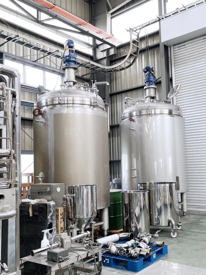 工場内の大型ステンレス製タンクと配管設備